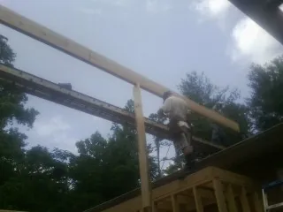 Carpenter setting a ridge beam over a new addition frame — Ice Dam Removal by Roofing Brothers in Hemlock