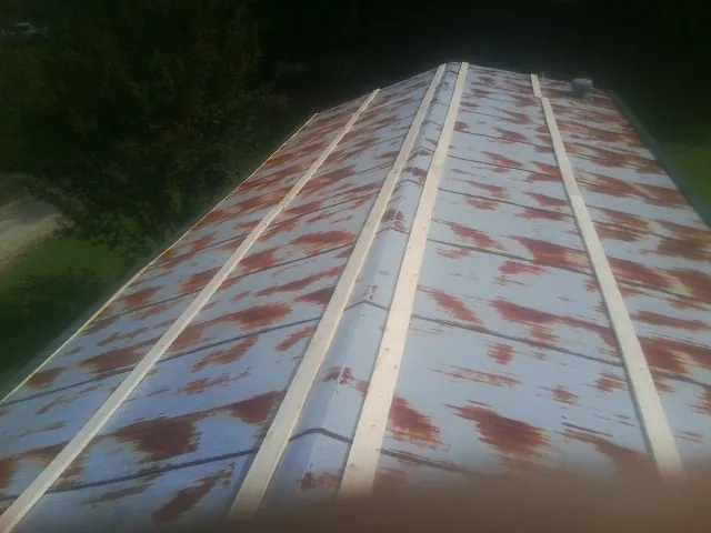 Rusted metal roof panels with new wood purlins before replacement — Storm Damage Roof Repair in Hemlock by Roofing Brothers