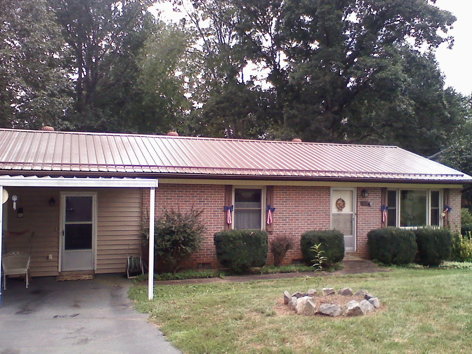 Bronze metal roof and carport on a brick ranch home — Roof Repair work by our crew in Hemlock
